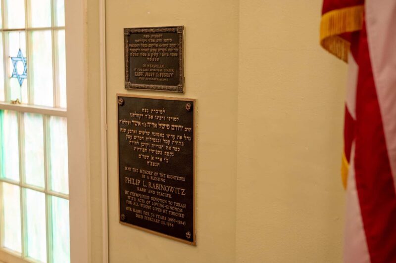 A large memorial plaque honoring Rabinowitz hangs in the synagogue’s sanctuary next to the bimah.