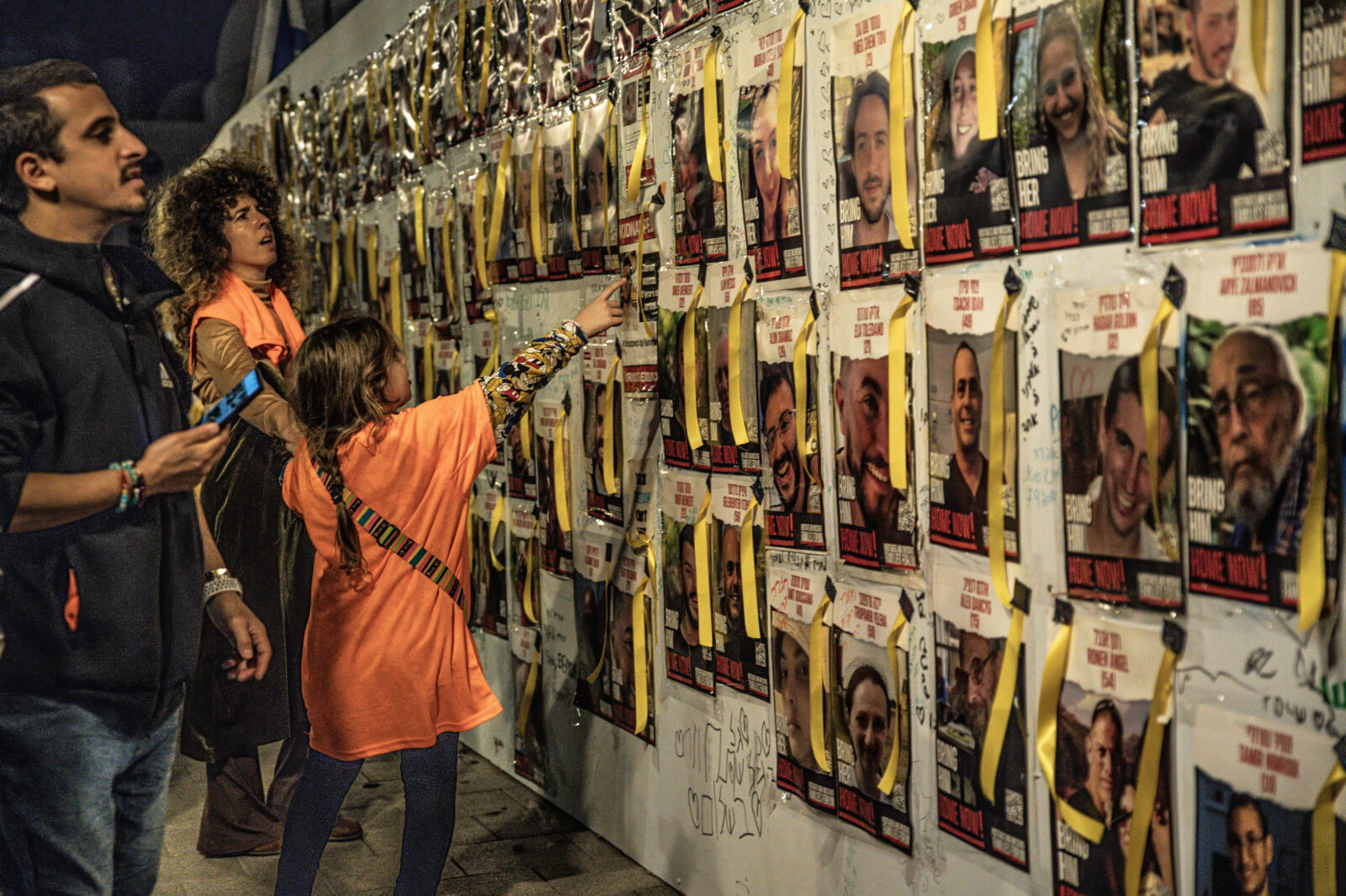 An Israeli child points at a poster of one of the Israeli hostages during a demonstration in Tel Aviv.